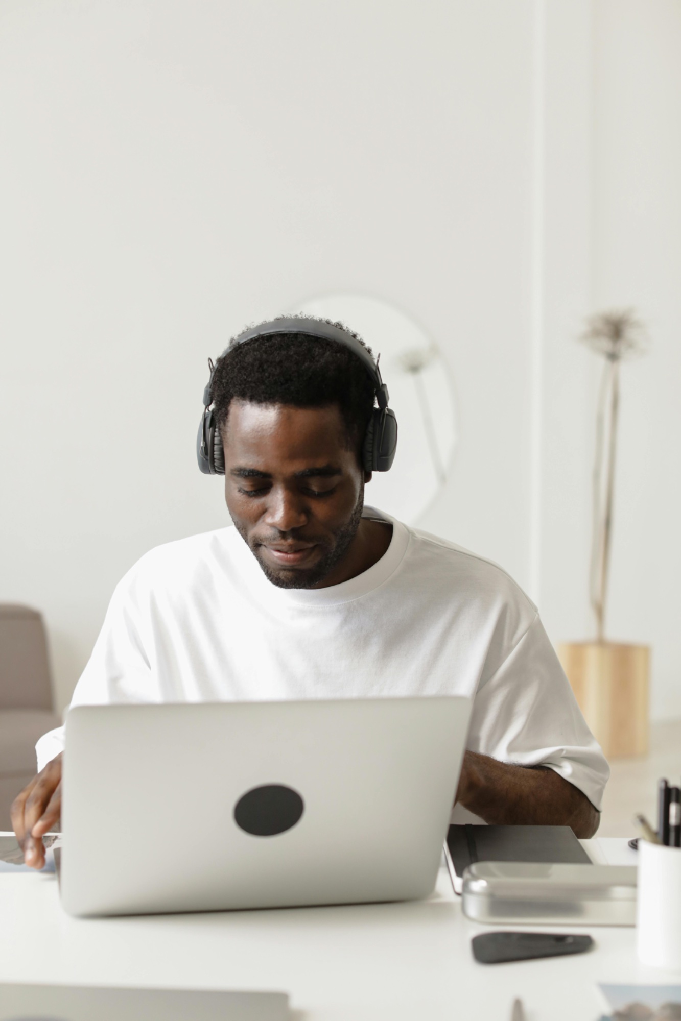 Visually impaired man wearing headphones while using a laptop